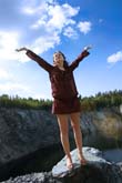 woman holding arms open against blue sky background