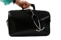 doctor hands holding black suitcase