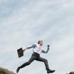 man holding a breifcase taking a leap