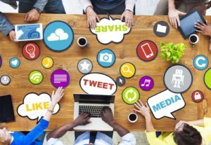 Team meeting with social media symbols all over wooden conference table