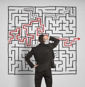 man looking at large maze drawing