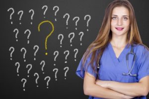 doctor standing next to chalkboard covered in question marks