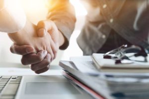 two people shaking hands after healthcare mergers and acquisitions meeting