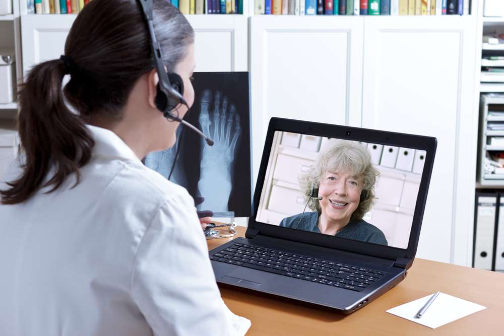 two females talking to each other via video chat both wearing headsets