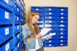 woman reads mail from mailbox