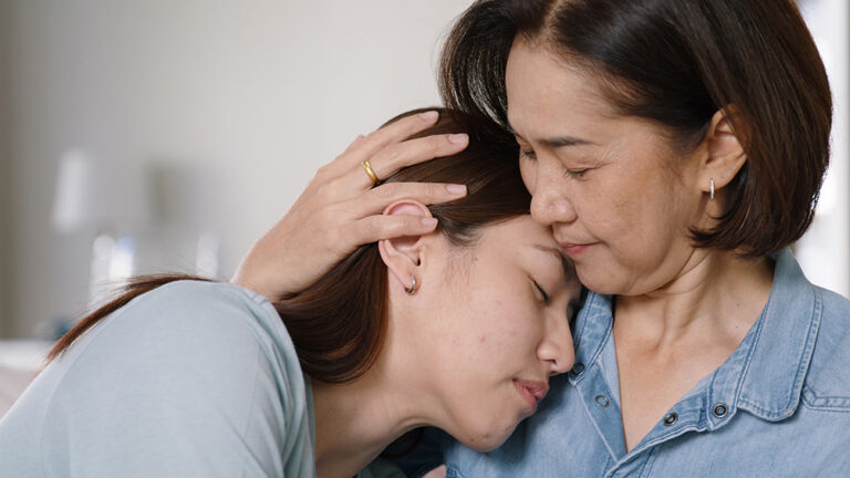 Mother hugging daughter