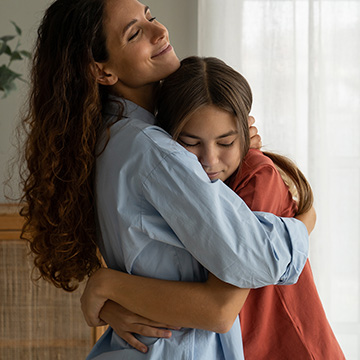 Mother hugging daughter